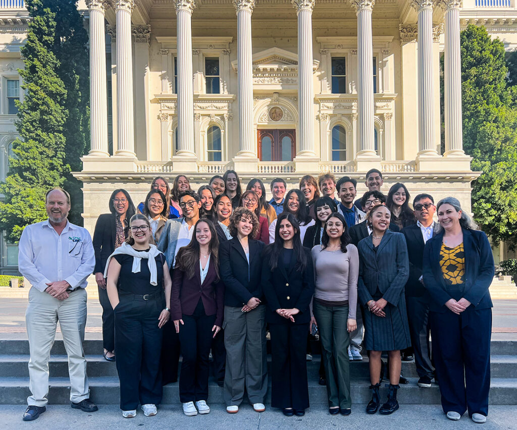 Students and mentors pose for a group photo in front of the Sacramento State Capitol buidling